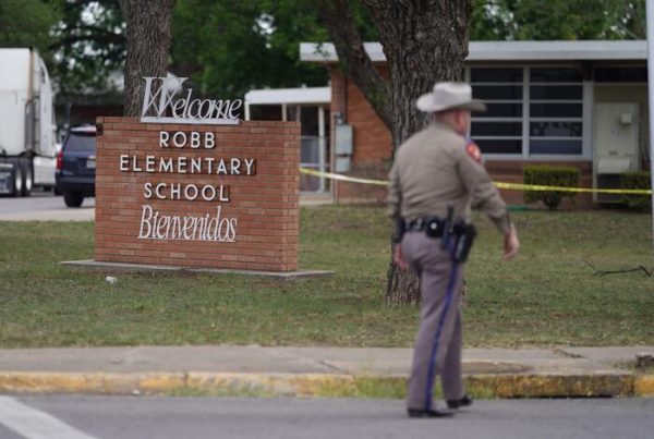 Un poliziotto cammina fuori dalla scuola elementare Robb a Uvalde, in Texas